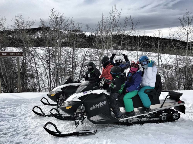group of happy riders snowmobiling in montana
