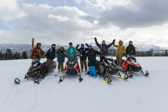 happy group snowmobiling in montana