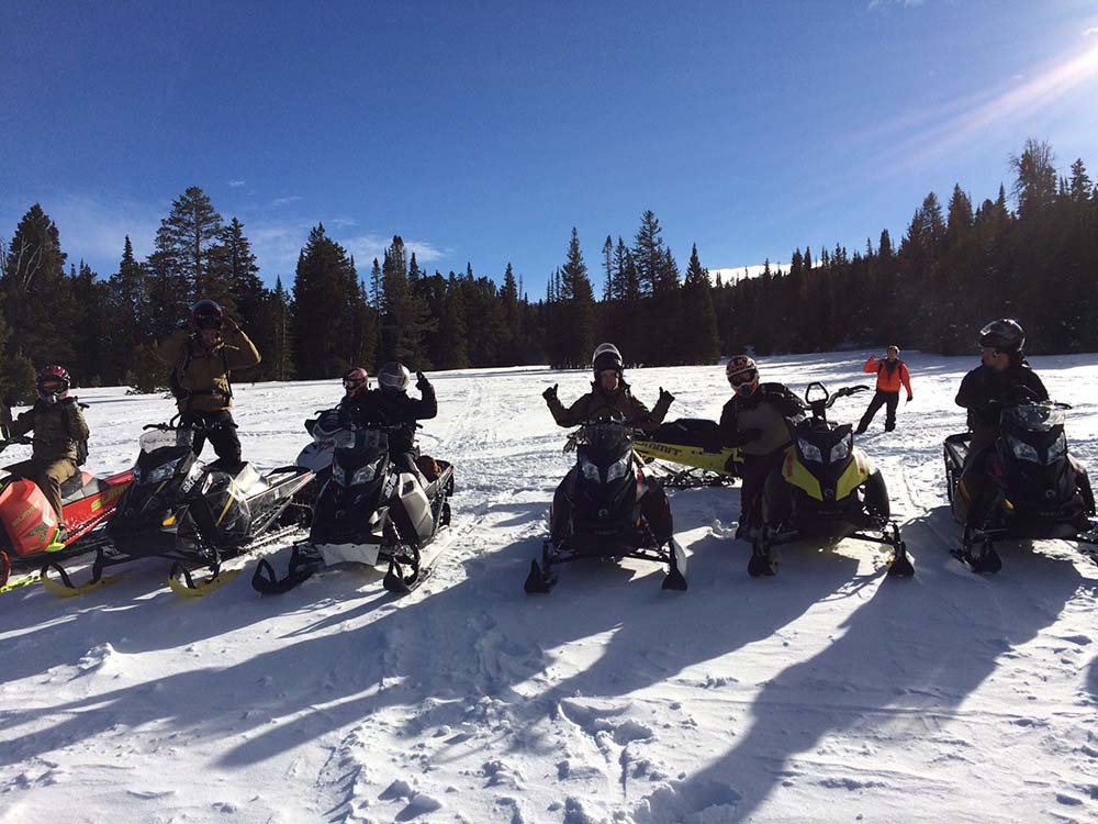 late in the day group snowmobiling in montana