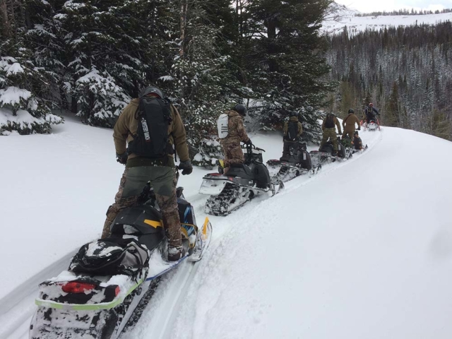 line of riders snowmobiling in montana