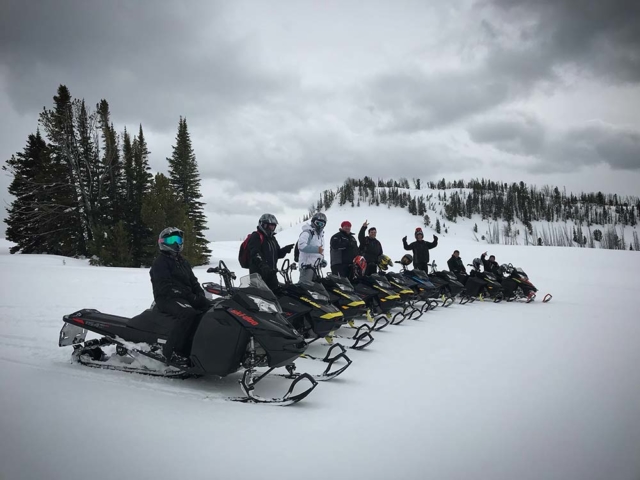 line of snowmobilers trail riding in montana