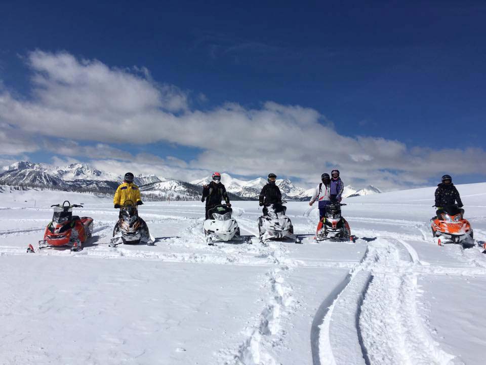 group of riders on flat plain snowmobiling in montana