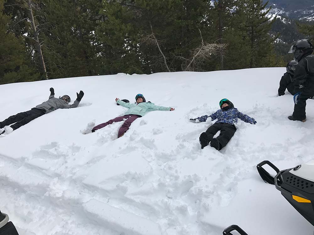 making snow angels while snowmobiling in montana