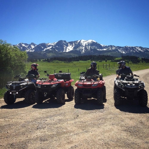 atv riders trail riding in montana with mountains in background